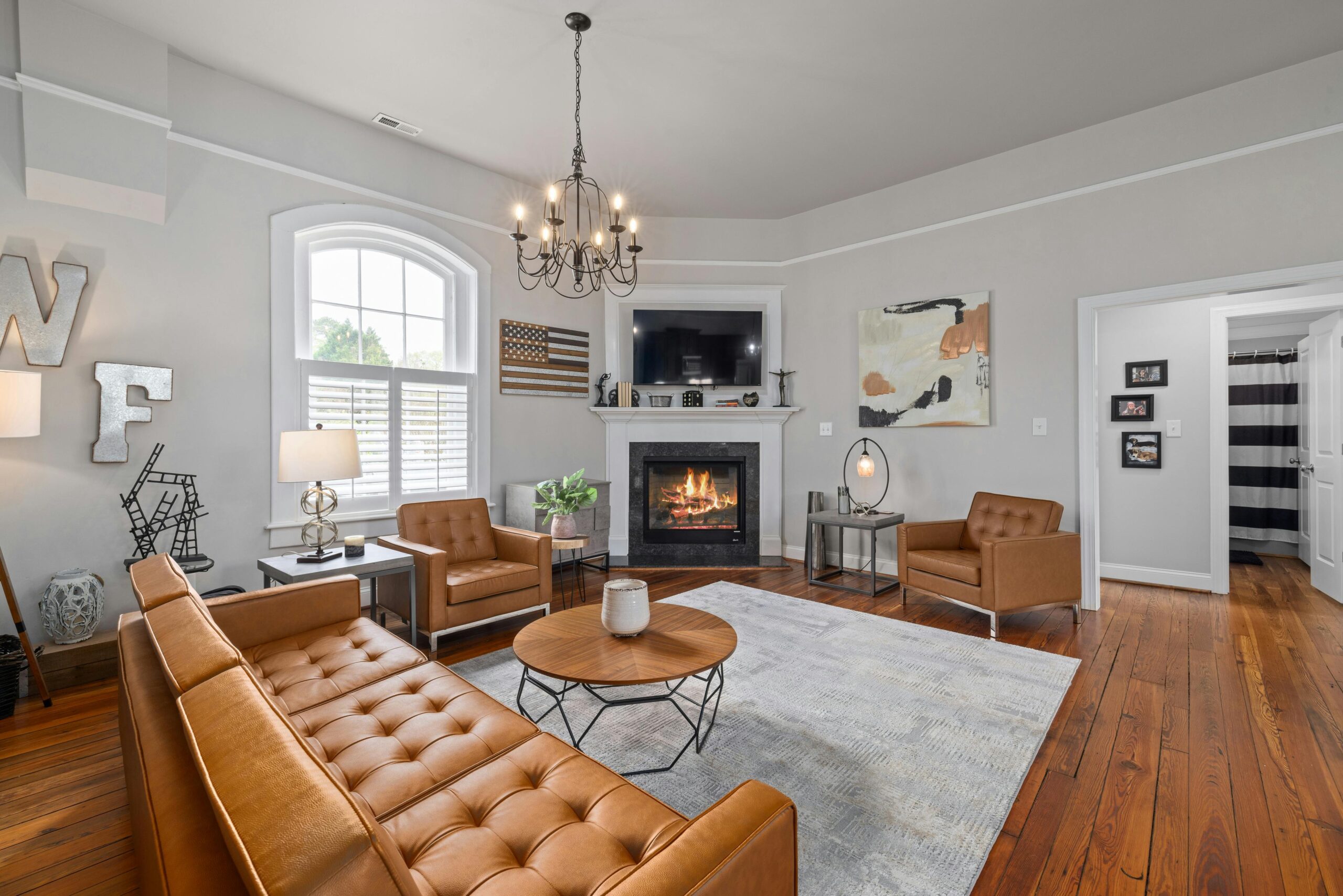 A stylish modern living room featuring elegant decor, leather furniture, and a cozy fireplace.