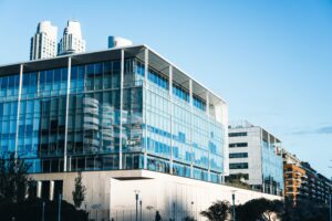 Low-angle view of a modern glass facade building in Buenos Aires' vibrant urban landscape.